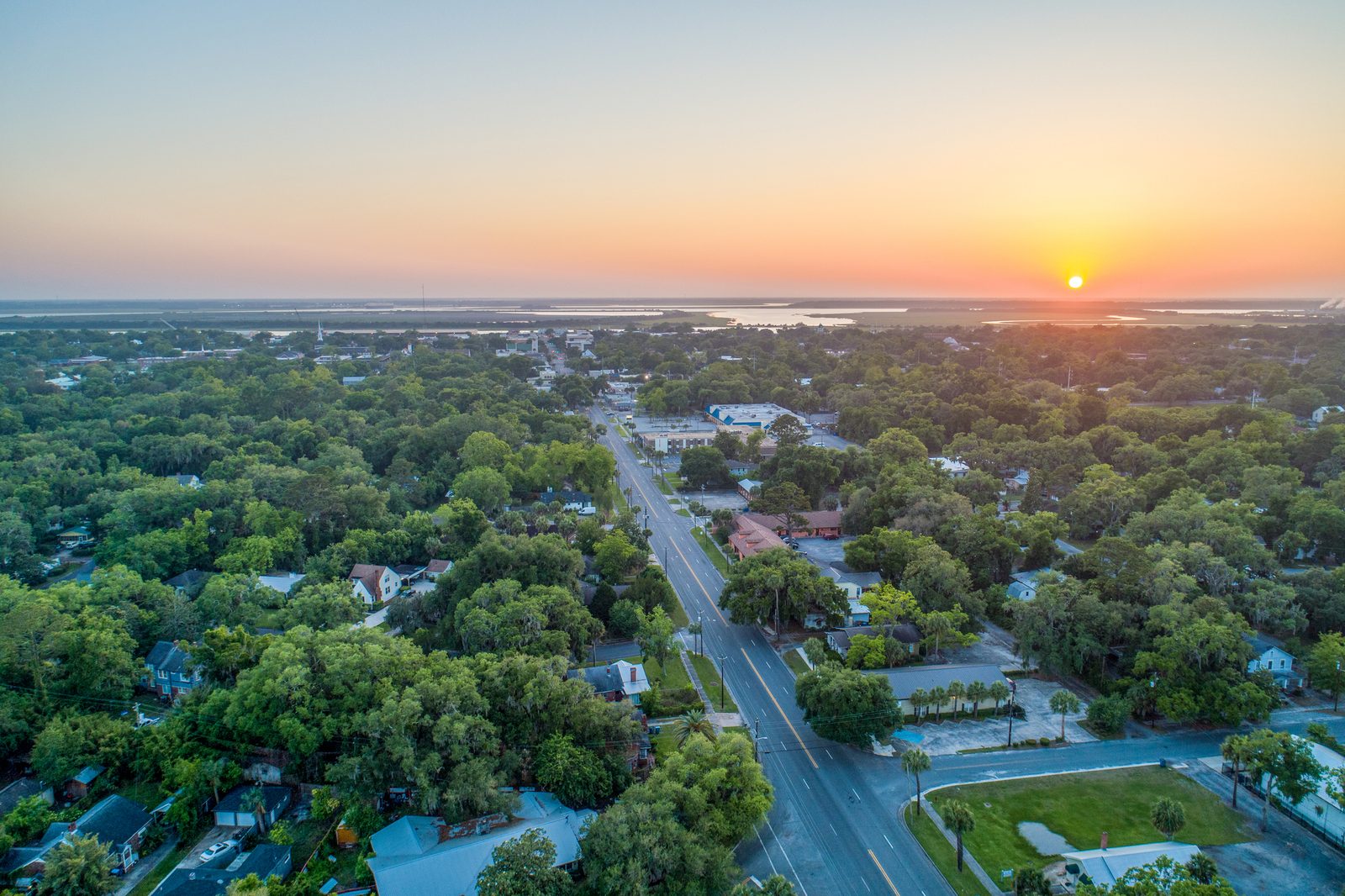 Aerial view of a tree-lined town and the coast at sunset in Glynn County, Georgia
