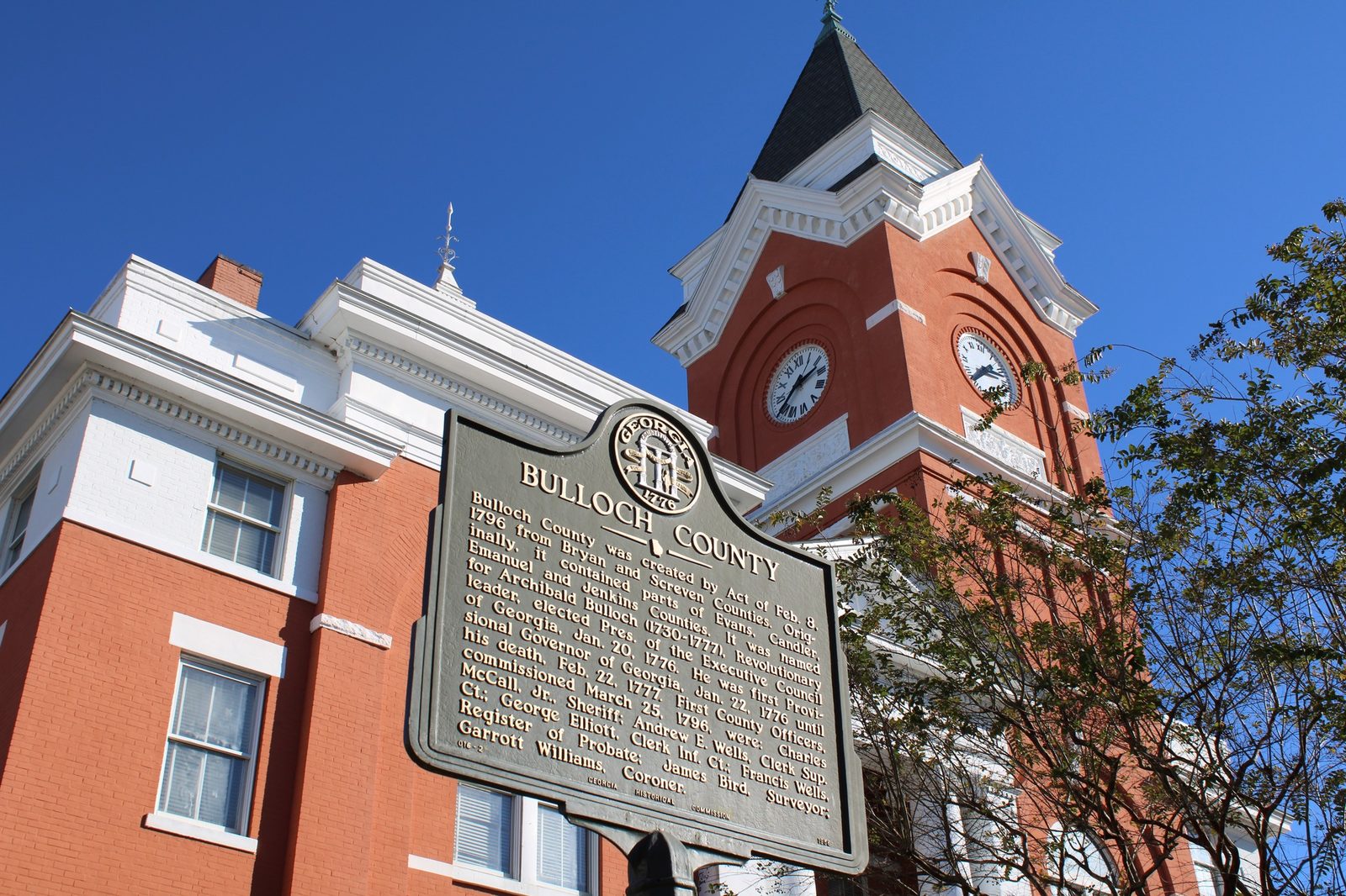 Brick courthouse with a white clock tower and a historical marker in Bulloch County, Georgia